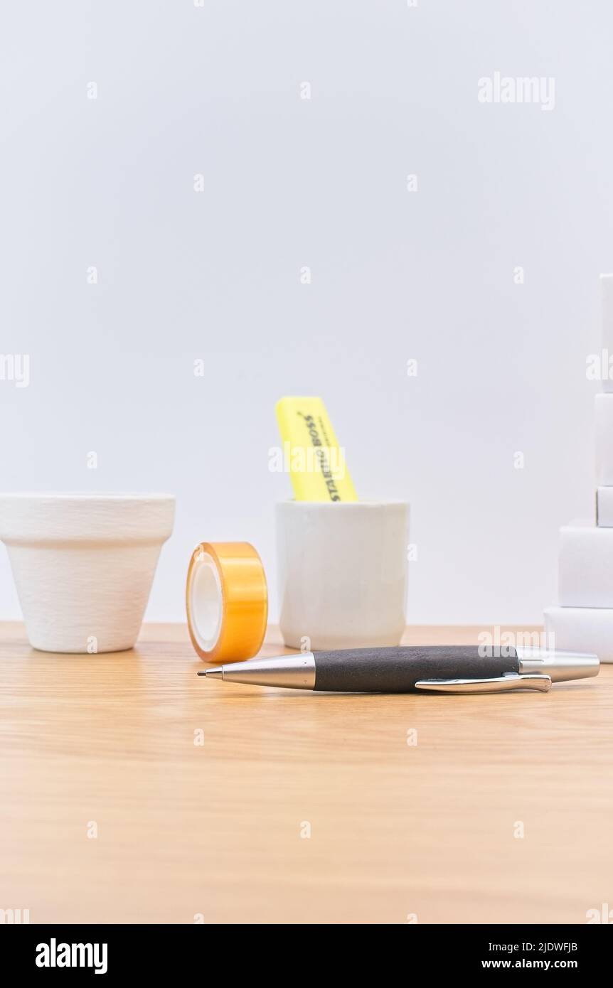 bright wooden office desk with consumables, books and supplies with