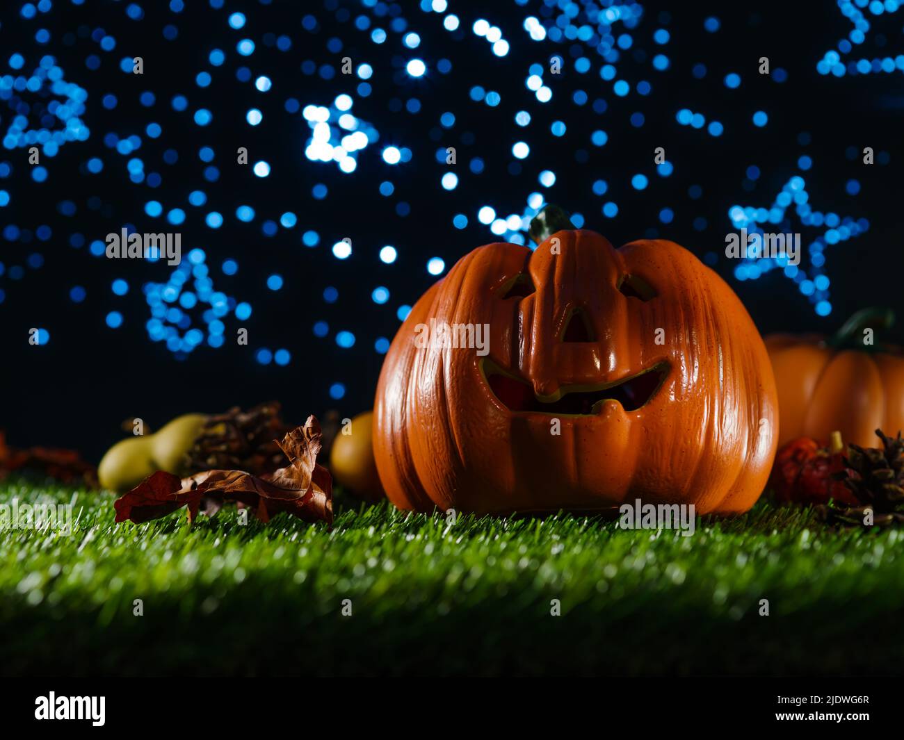 Halloween background. On the green grass smiling orange pumpkin, autumn ...