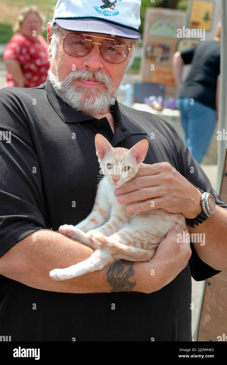 senior man with his pet cat who is a family member Stock Photo