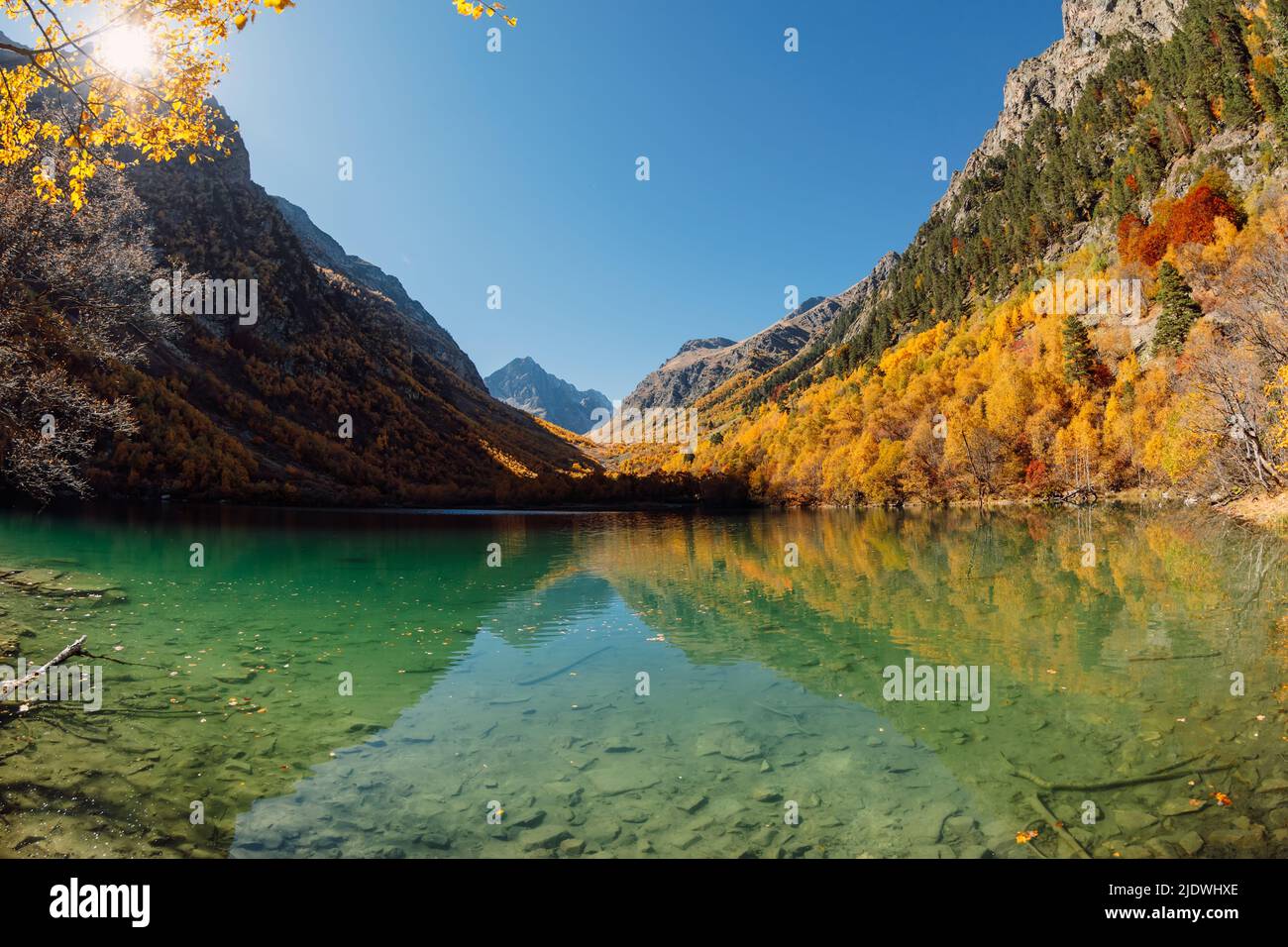 Mountain lake with transparent water and colorful autumnal trees ...