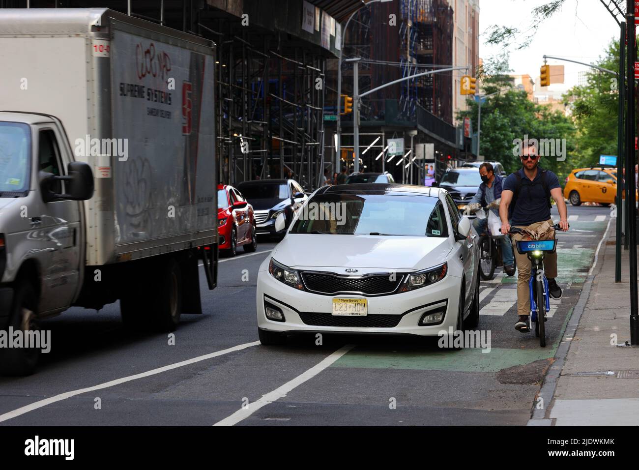 An illegally parked car blocking a bike lane in New York City. car blocking a bicycle lane in Manhattan. June 20, 2022. Stock Photo