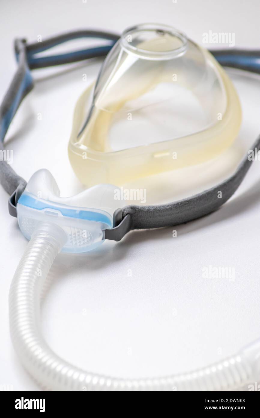 CPAP mask as full face mask or nose mask against obstructive sleep apnea helps patients respirator mask headgear clip for nose and throat breathing Stock Photo