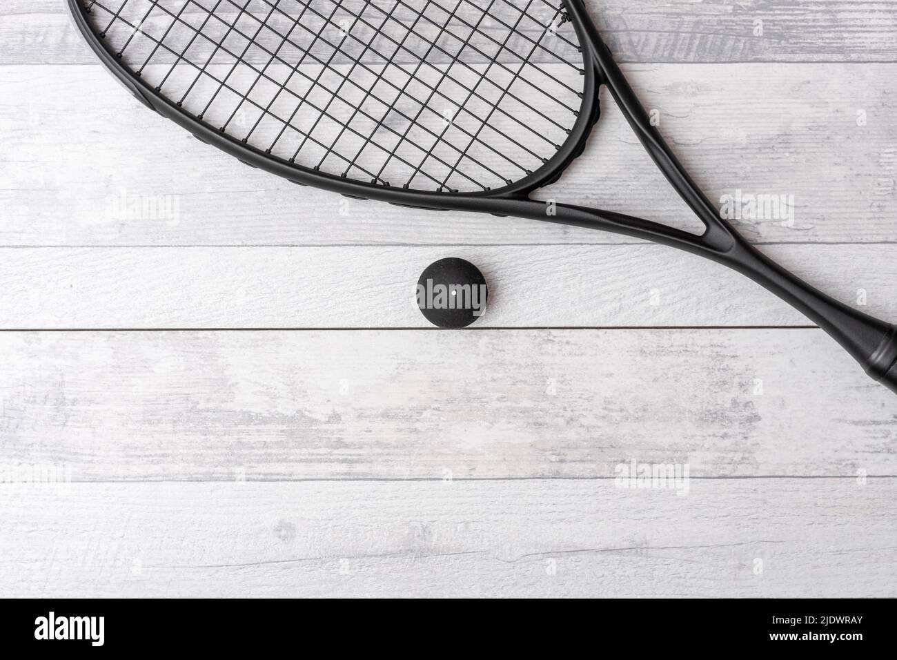 Black squash racket and ball on grey court. Horizontal sport theme poster, greeting cards, headers, website and app Stock Photo