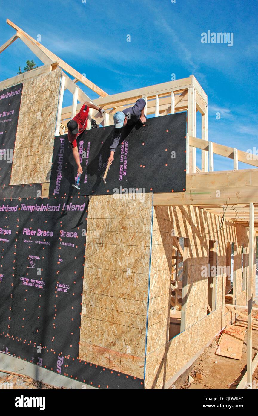 Installing insulation on new home construction of wood and fiber by ...