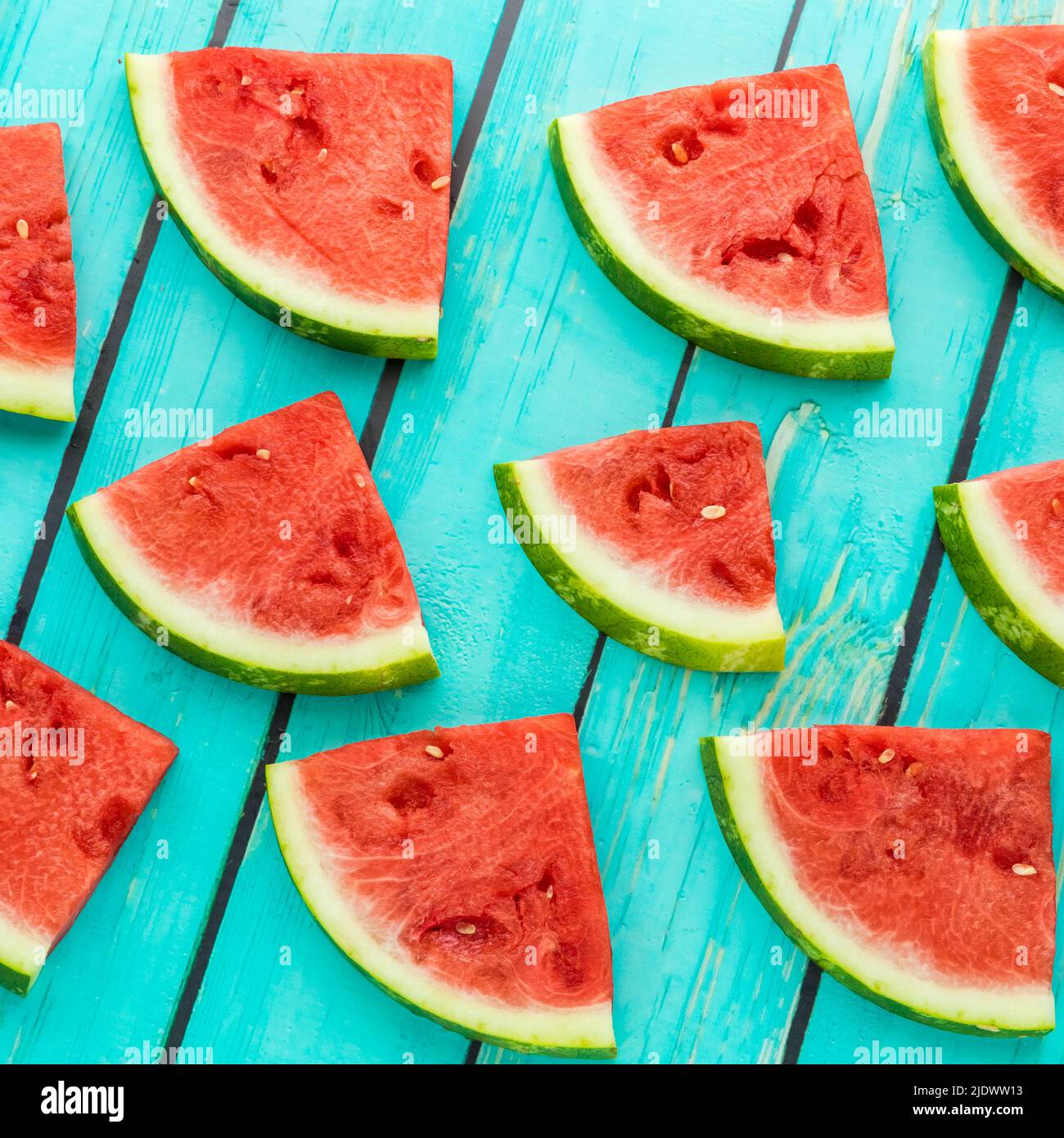 Top down view of slices of fresh watermelon against a bright blue ...