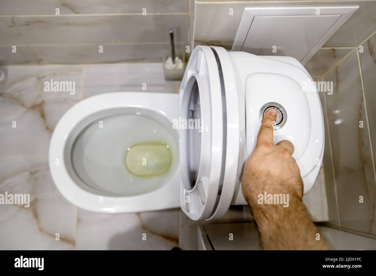 finger pressing the water drain button on the storage tank of the