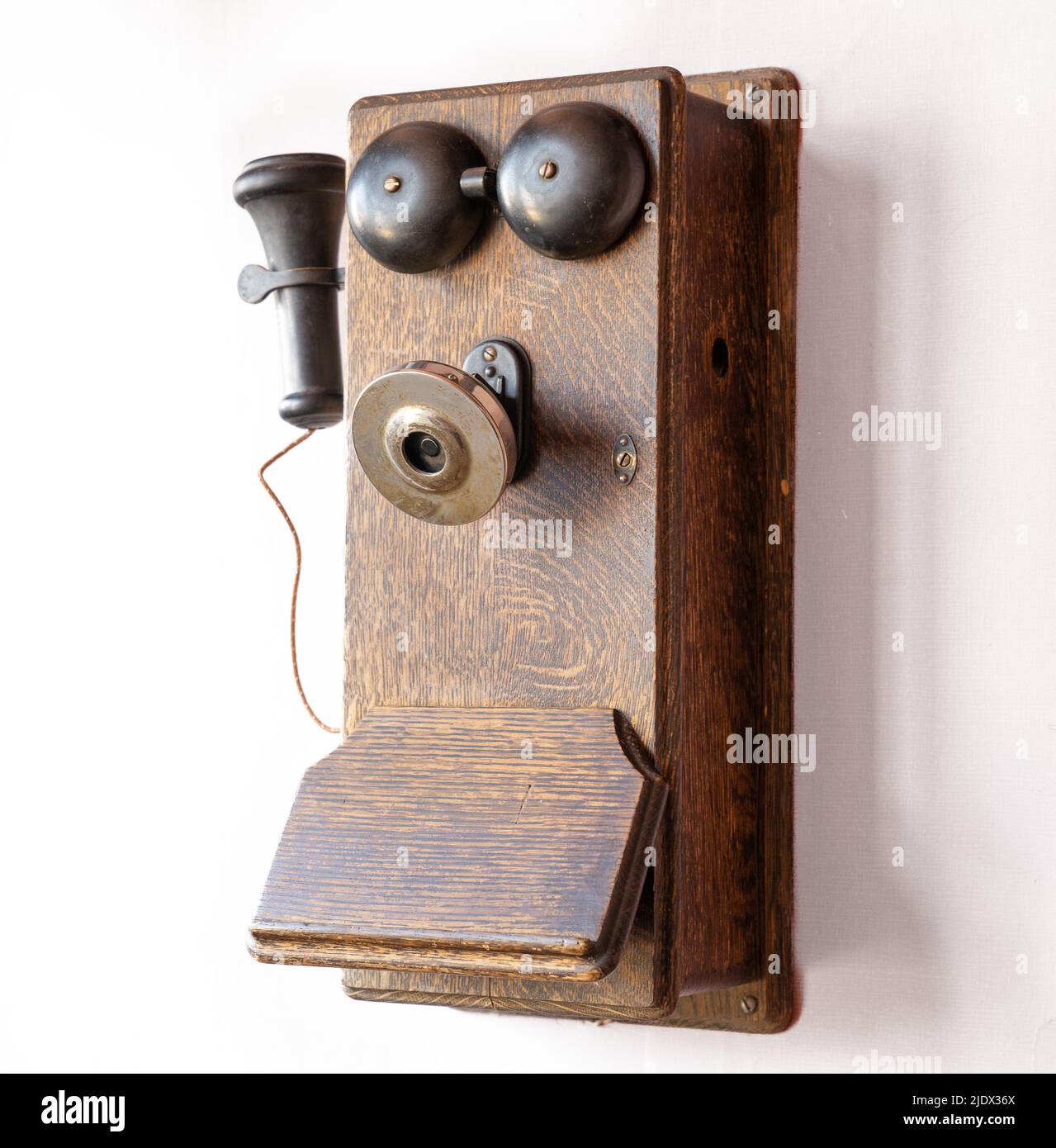 Old antique obsolete wooden wall mounted telephone Stock Photo