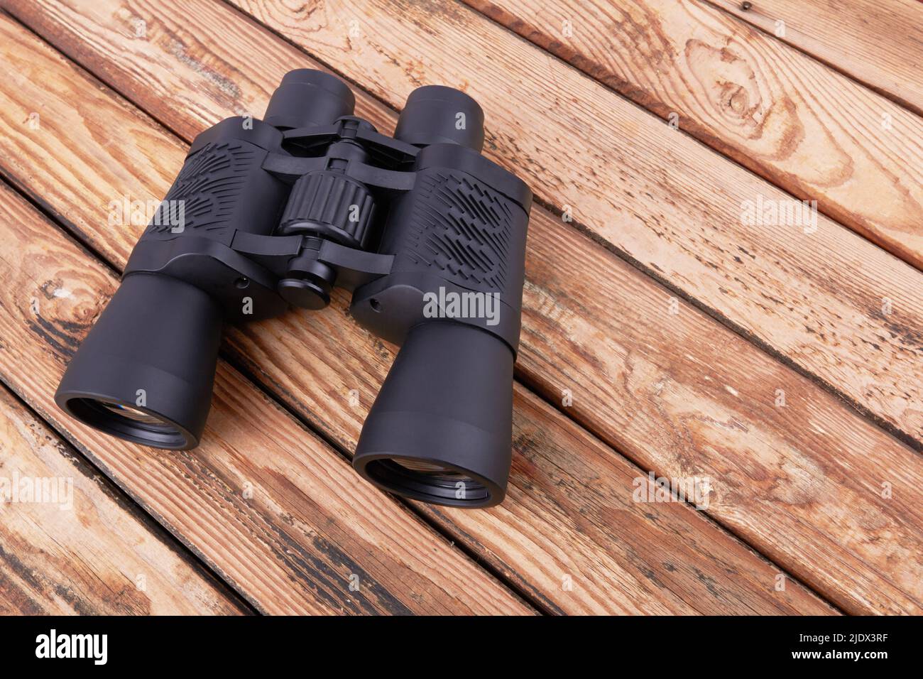 Black binocular on a wooden surface Stock Photo