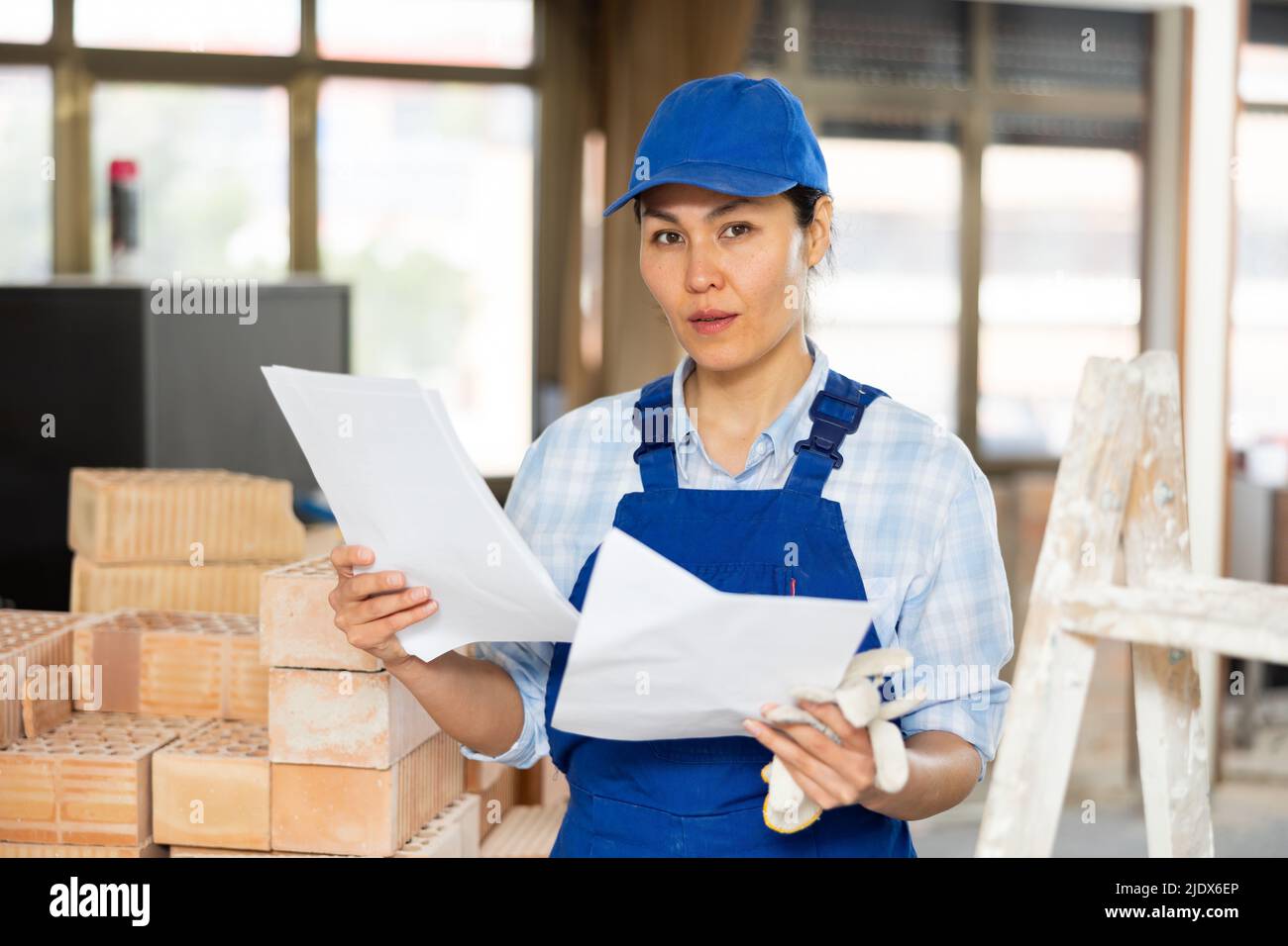 Woman making notes on indoor construction site Stock Photo