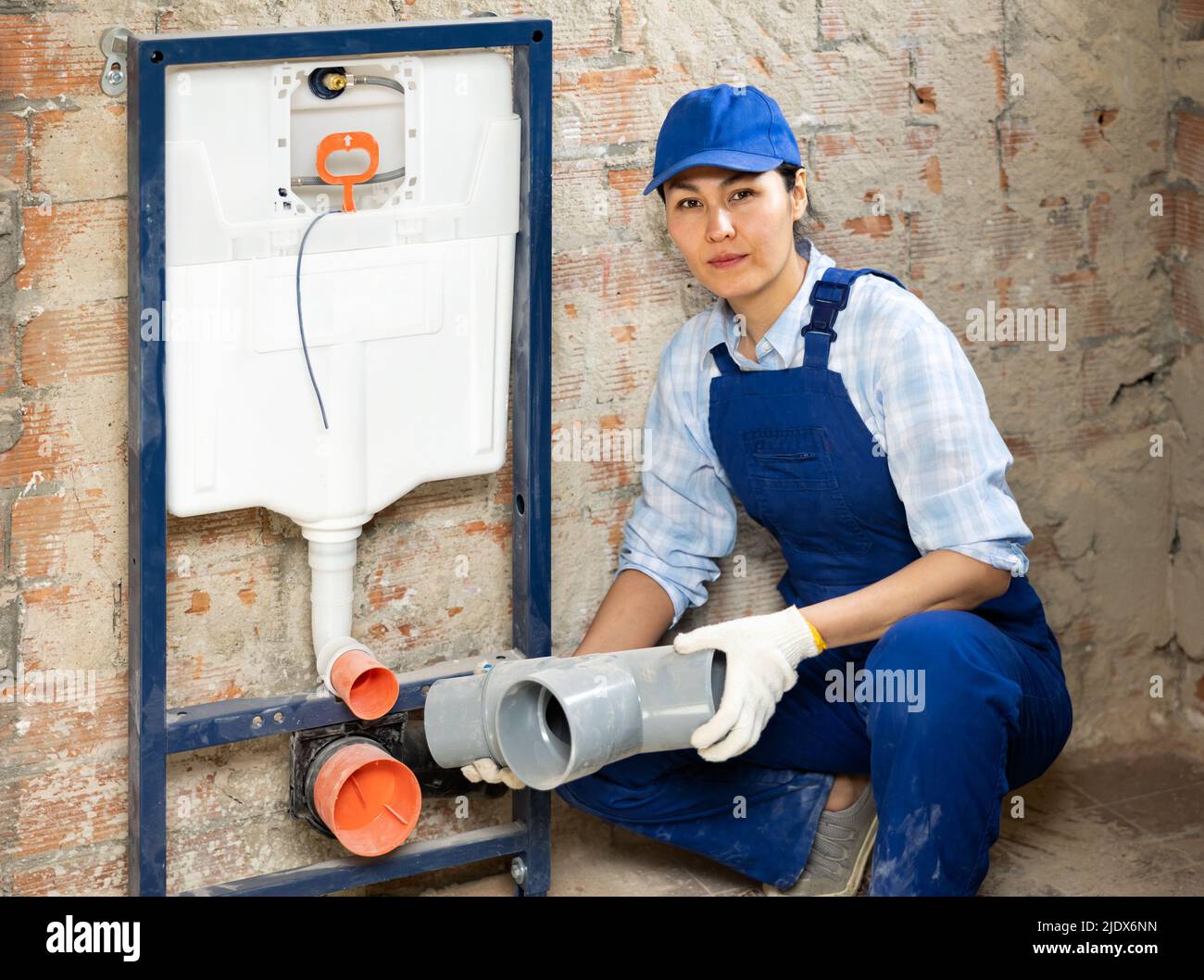Plumber installing back to wall toilet system Stock Photo Alamy