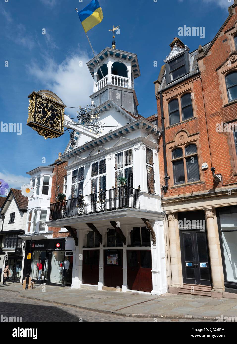 The 16th century Grade I listed Guildhall on Guidford High Street flying th flag of Ukraine on a summer morning, Surrey, England, UK Stock Photo