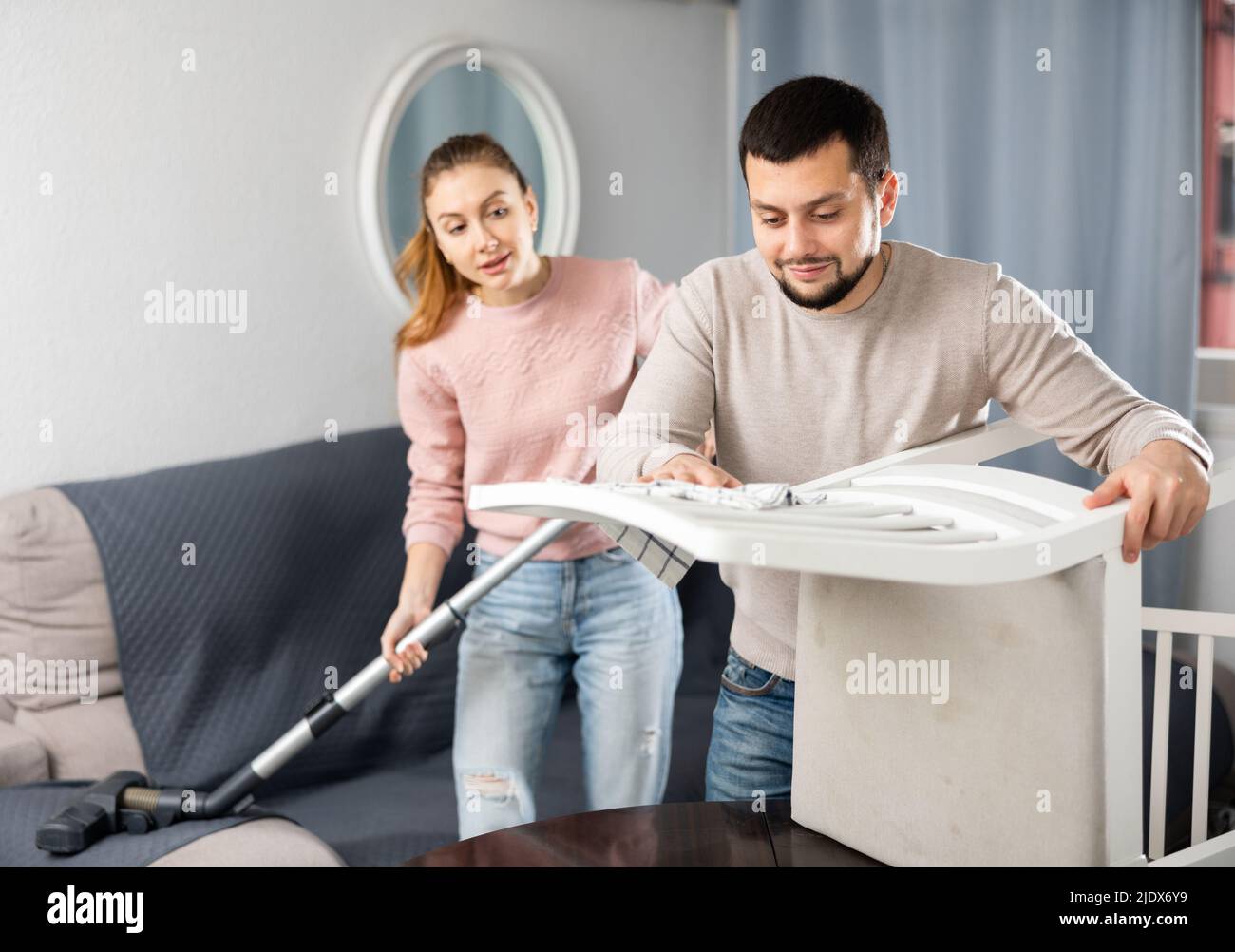 Young couple cleaning table in living room Stock Photo
