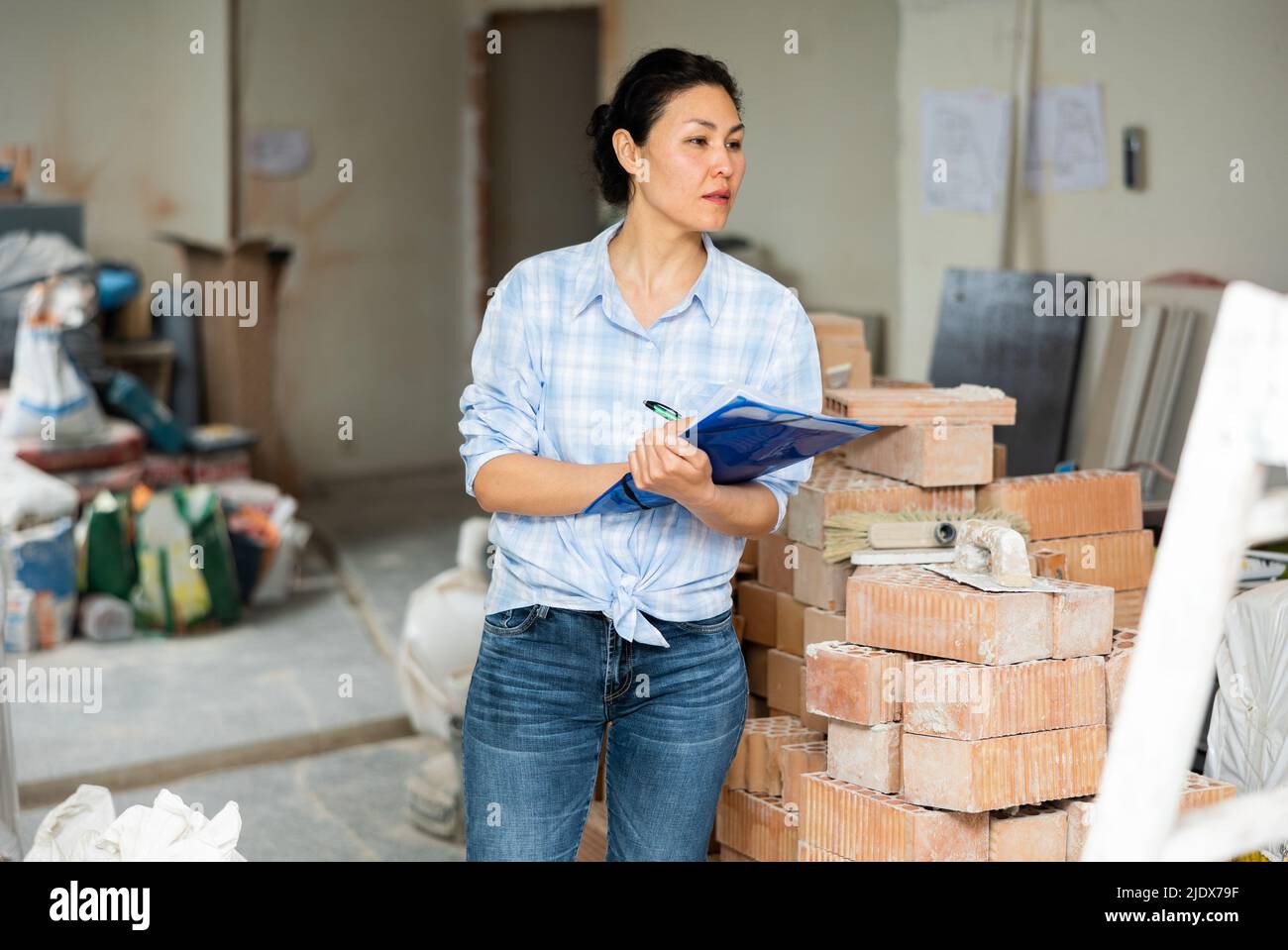 Woman making notes at renovating house Stock Photo