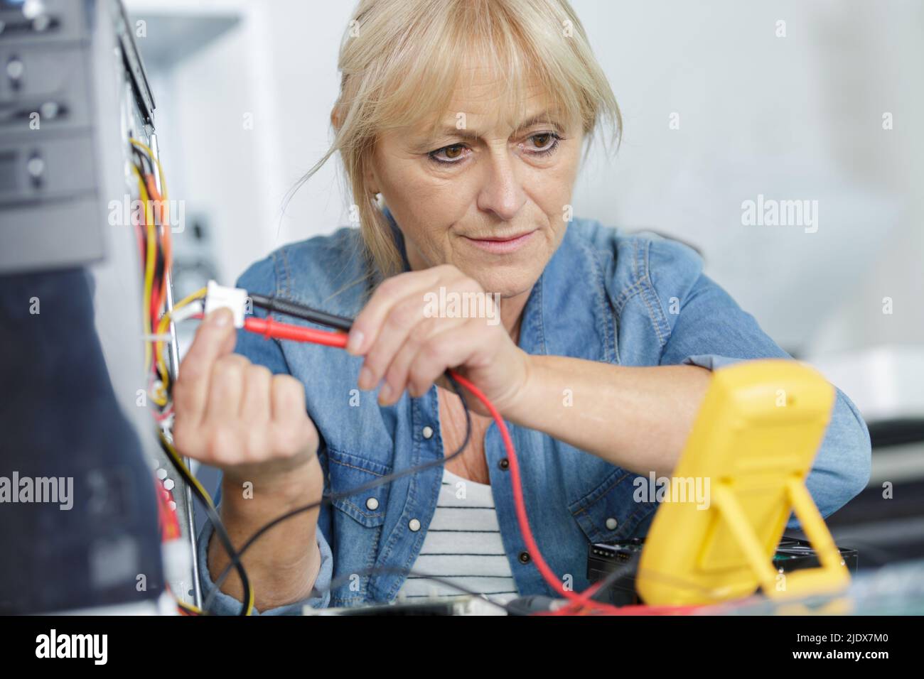 senior female technician using voltage meter Stock Photo