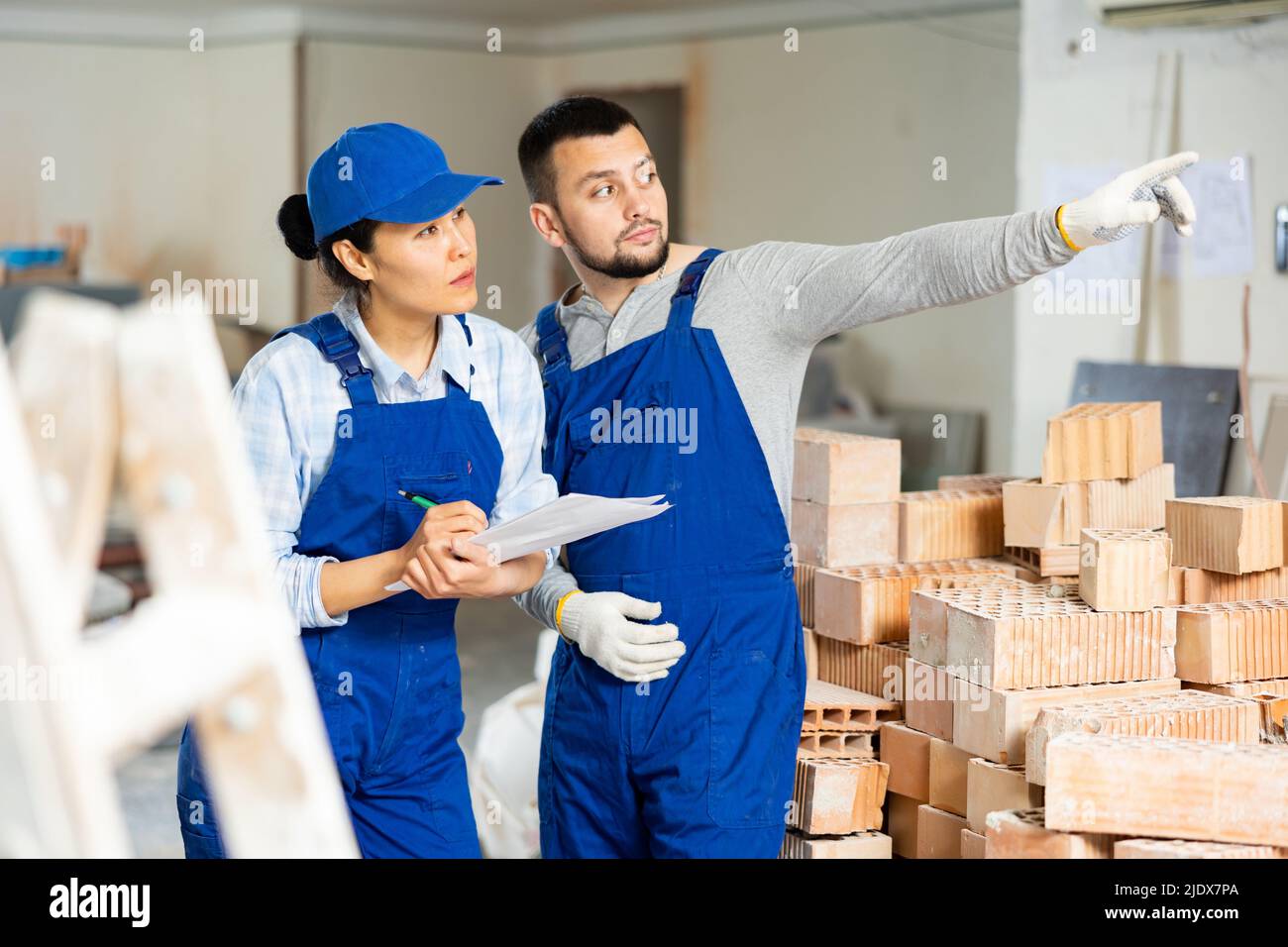 Woman and man repairers talking about documentation Stock Photo
