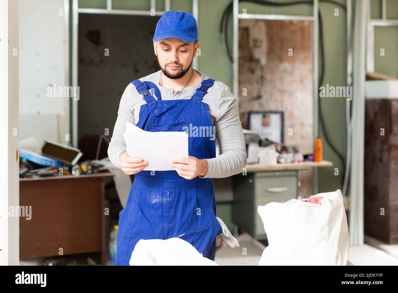 Foreman reading papers on indoor construction site Stock Photo