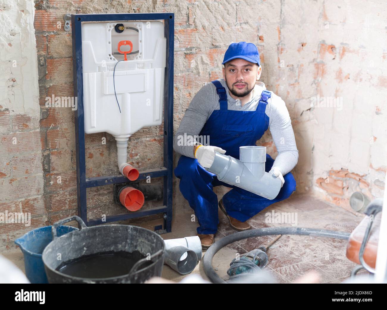 Plumber installing back to wall toilet system Stock Photo Alamy