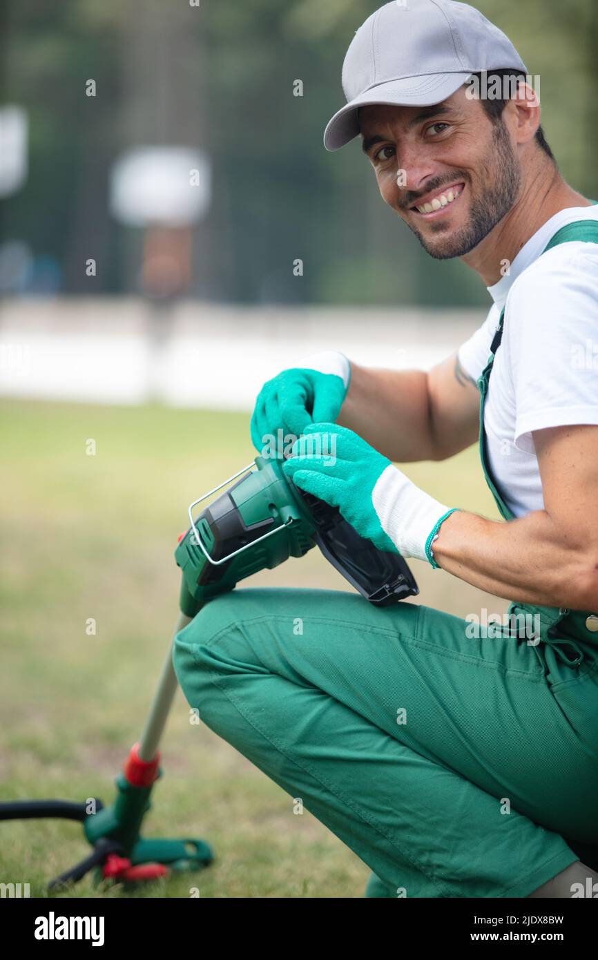 man adjusting the cord on his strimmer Stock Photo