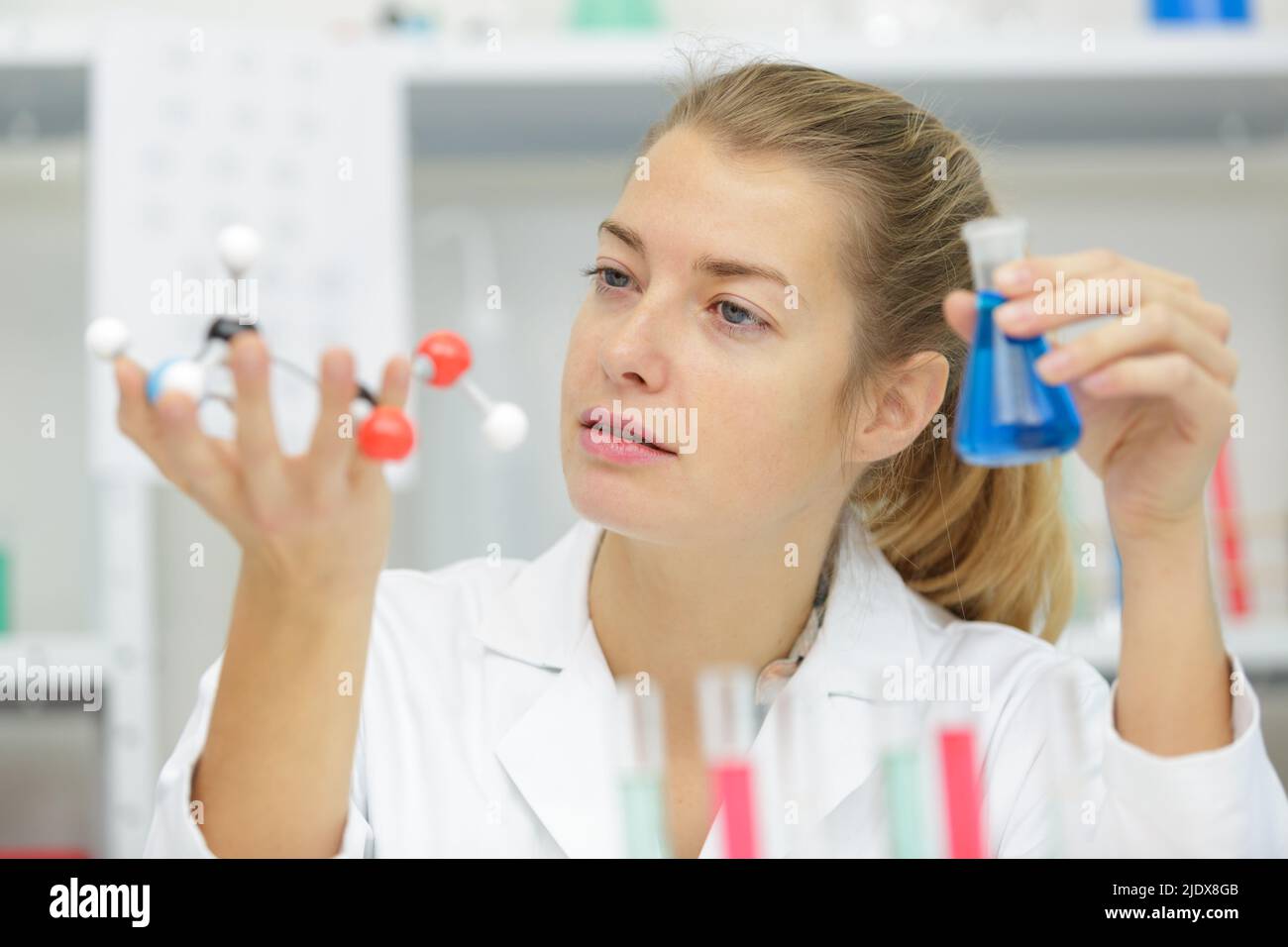 female scientist holding model dna and glass flask Stock Photo Alamy