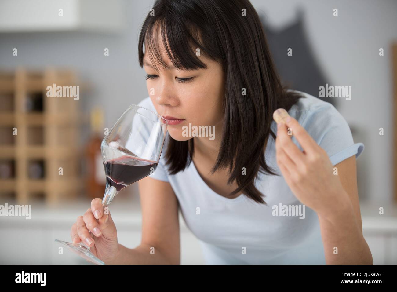 closeup portrait of young female smelling red wine Stock Photo