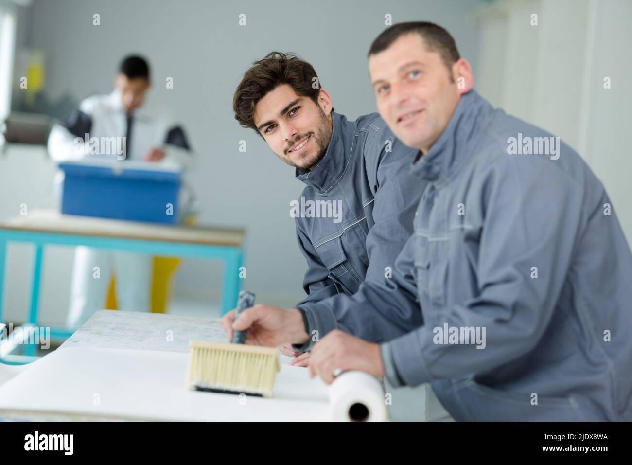 painter and apprentice painting a plank white Stock Photo Alamy