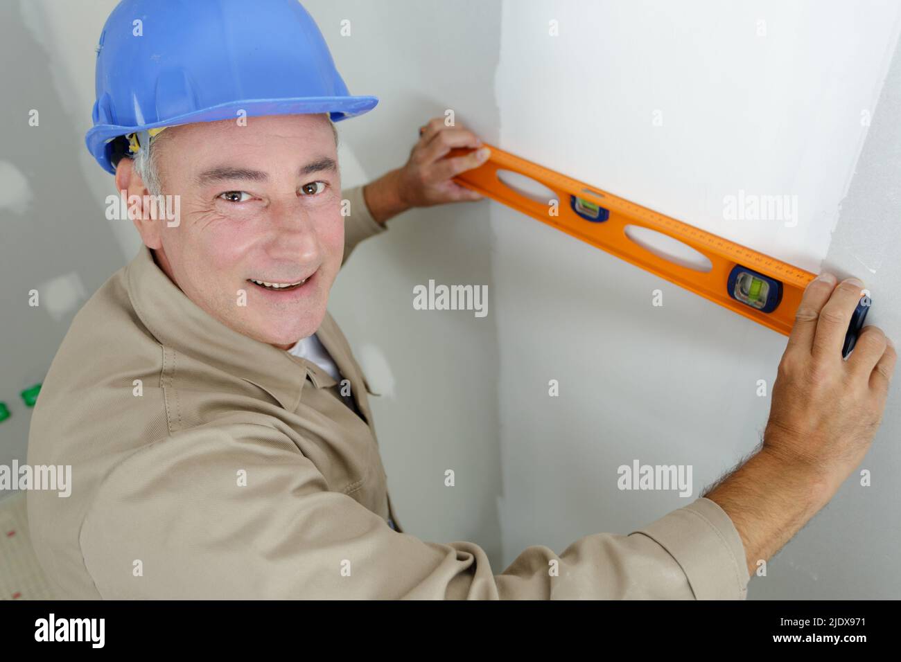 man measures the wall with a level Stock Photo