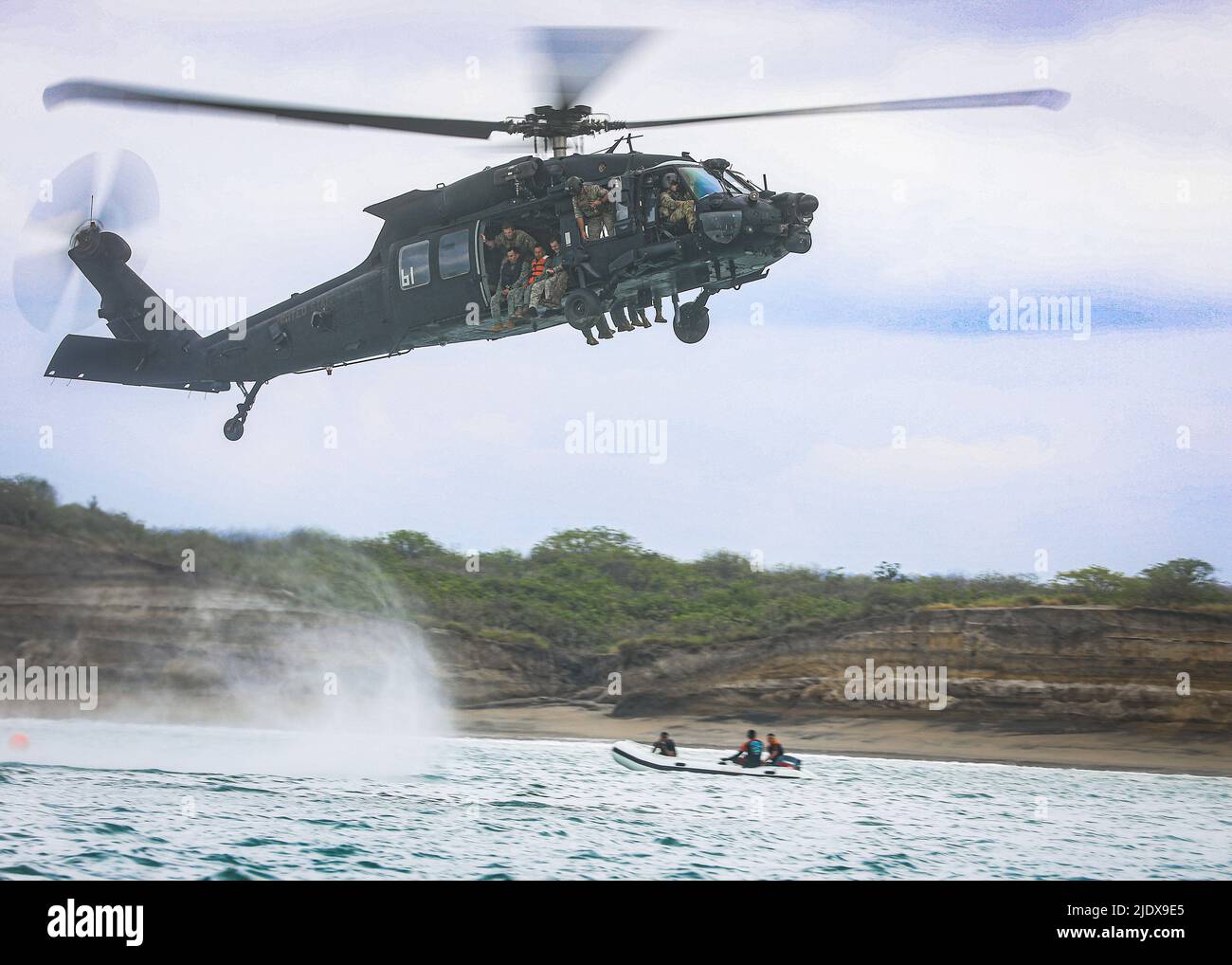 A Modified Helicopter-60 (MH-60) descends to the water for a HELOCAST operation in Ecuador on May 18, 2022. The overall exercise promotes military-to-military relationships, increases mission readiness, and improves regional security.    (U.S. Army photo by Spc. Christopher Sanchez) Stock Photo