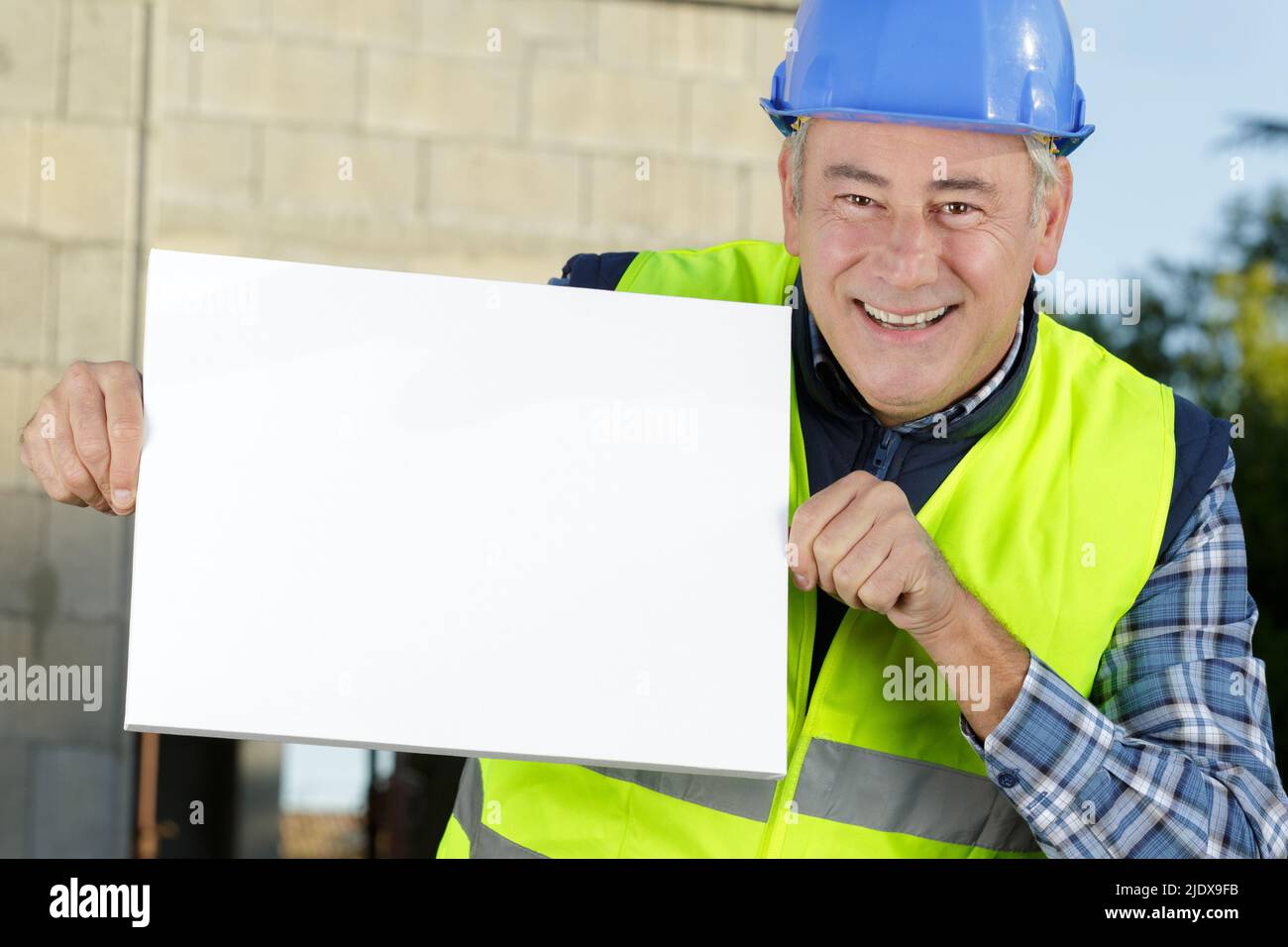 happy builder holding a white board Stock Photo