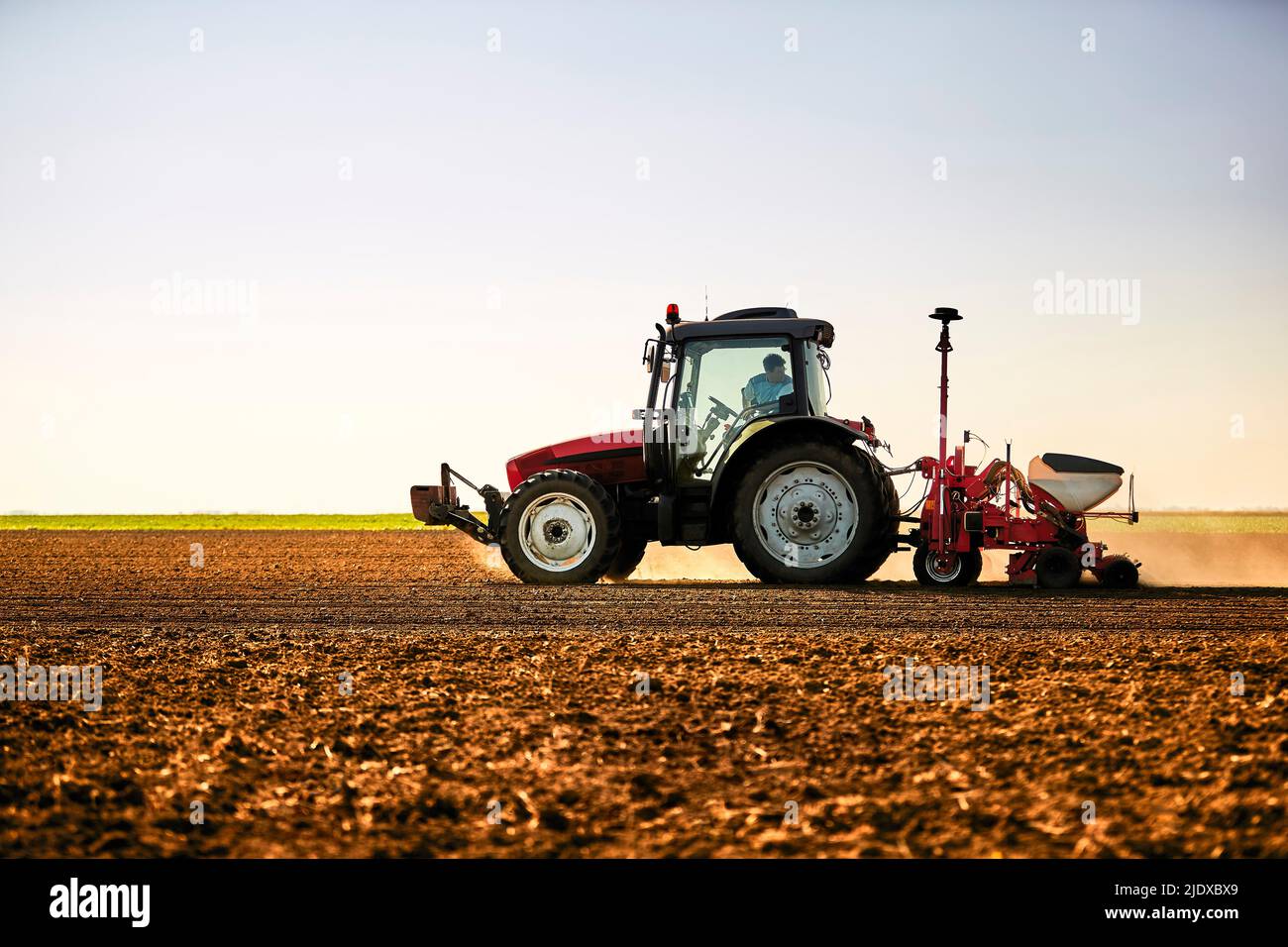 Farmer in tractor seeding soybean crops in field Stock Photo Alamy
