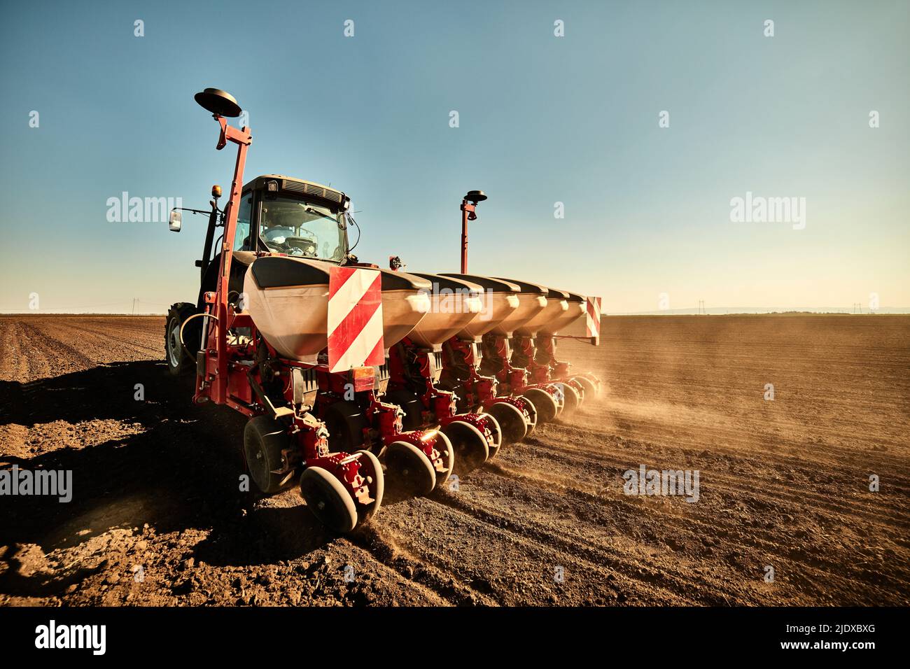 Tractor with seeder machine sowing seed in soybean farm Stock Photo
