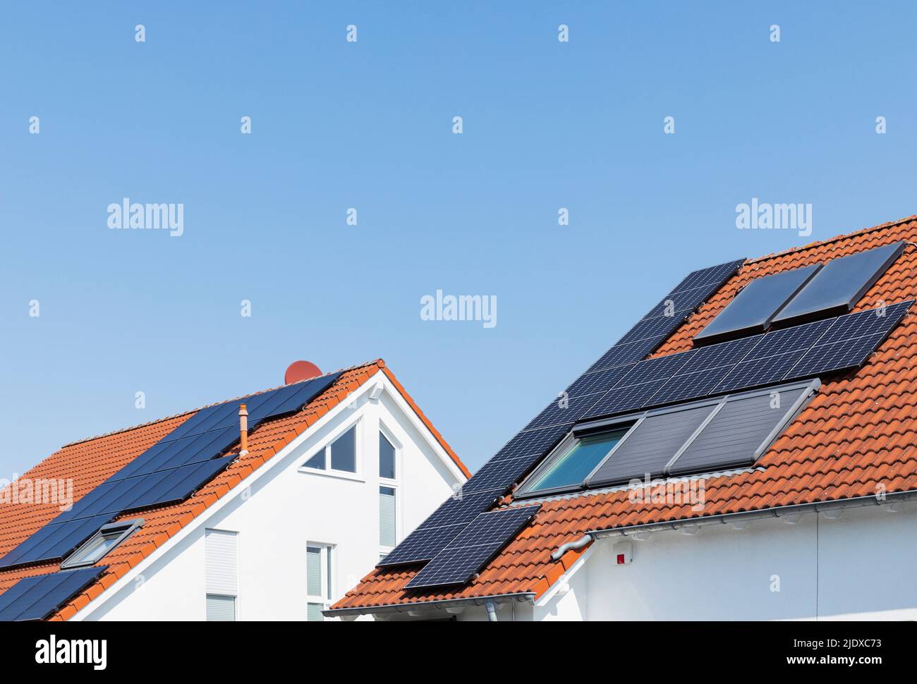 Germany, North Rhine-Westphalia, Solar panels on tiled roofs of modern suburban houses Stock Photo