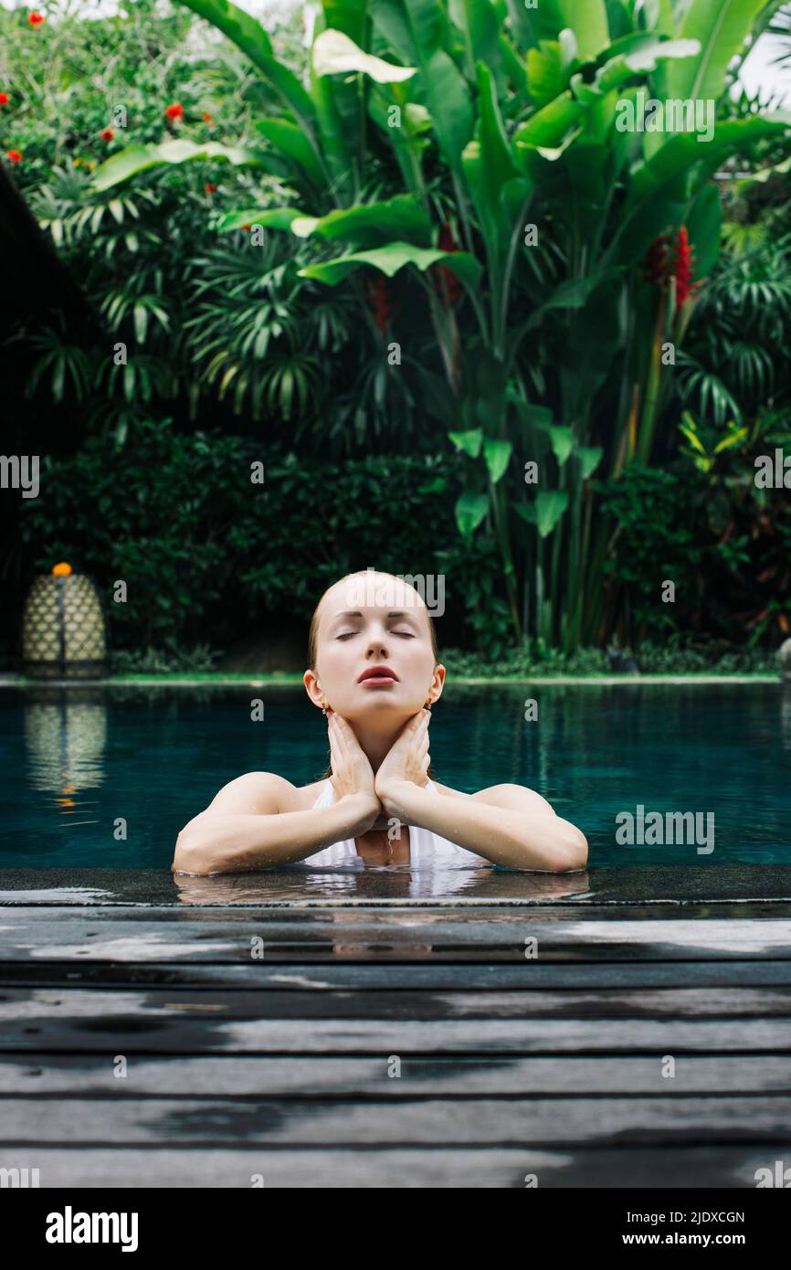 Indonesia, Bali, Portrait of young woman relaxing in swimming pool Stock Photo