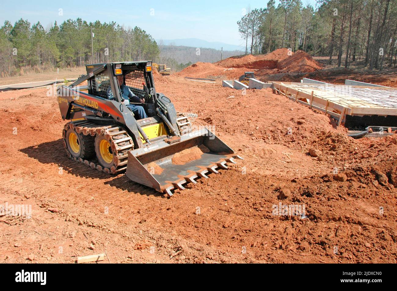 Bobcat dirt work around new foundation for new home construction Stock
