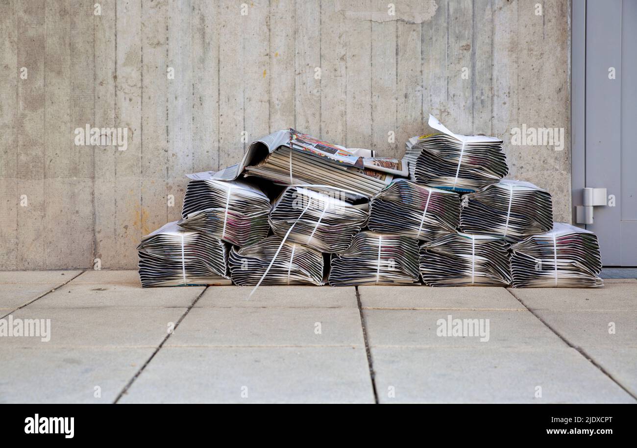 Newspaper stacks lying in front of apartment building Stock Photo Alamy