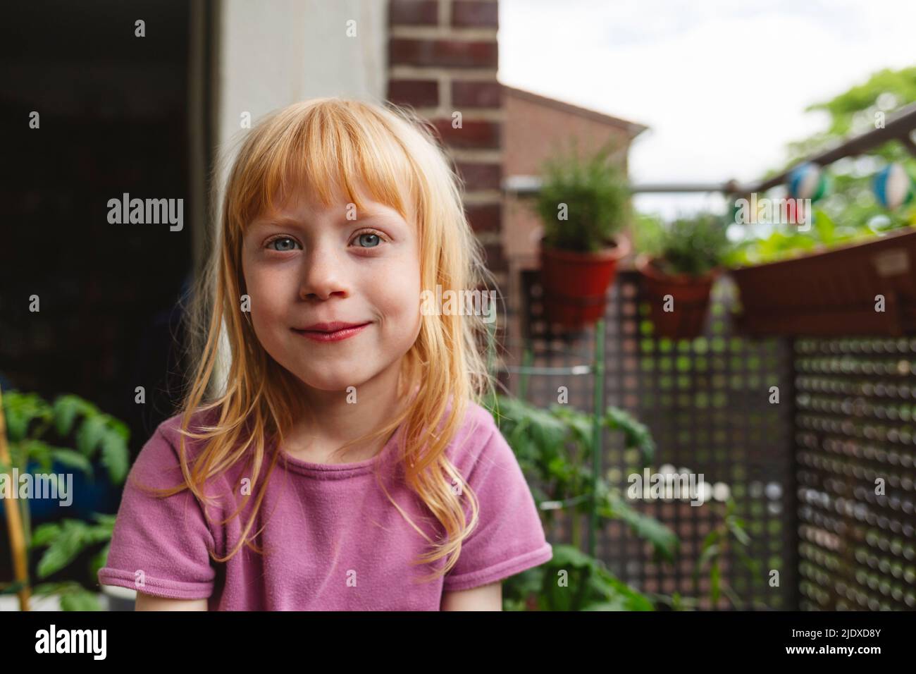 Girl sitting on balcony hi-res stock photography and images - Alamy