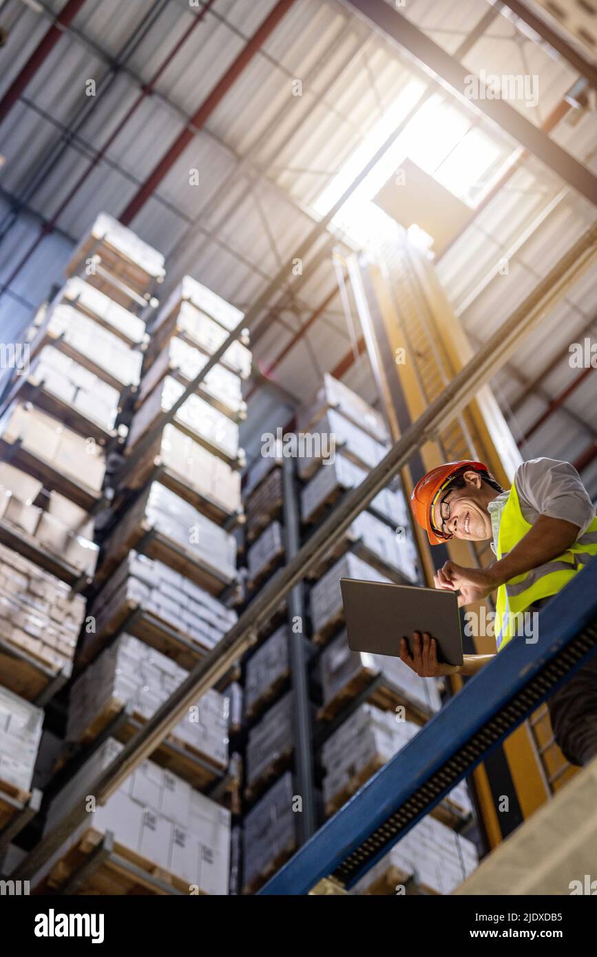 Smiling worker using tablet PC in warehouse Stock Photo