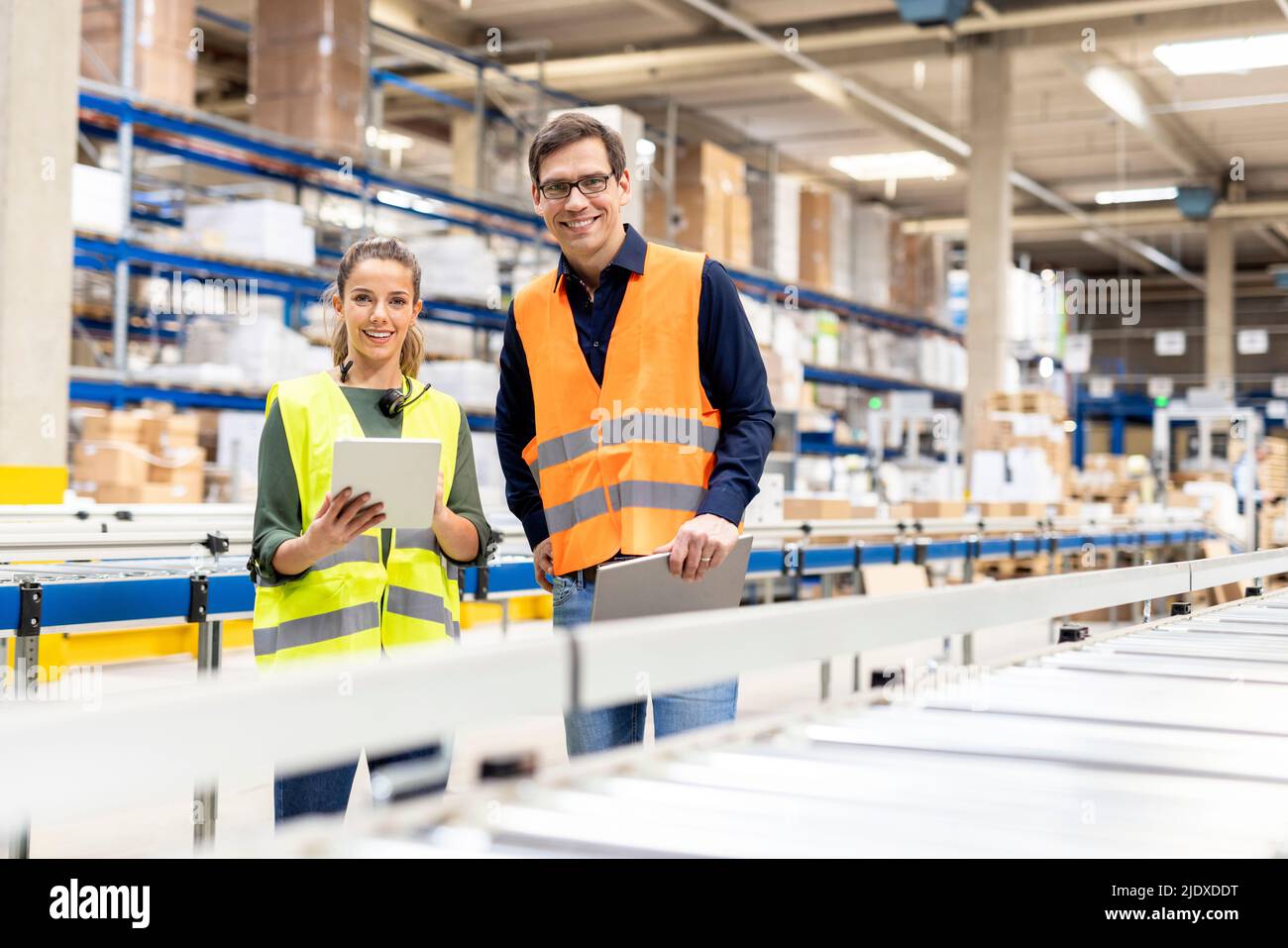 Smiling workers with tablet PC standing together in warehouse Stock Photo