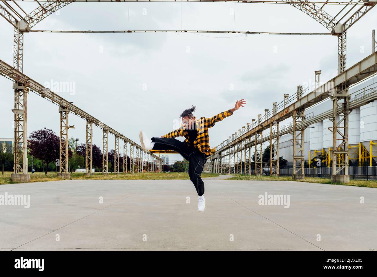 Happy young man jumping on footpath Stock Photo