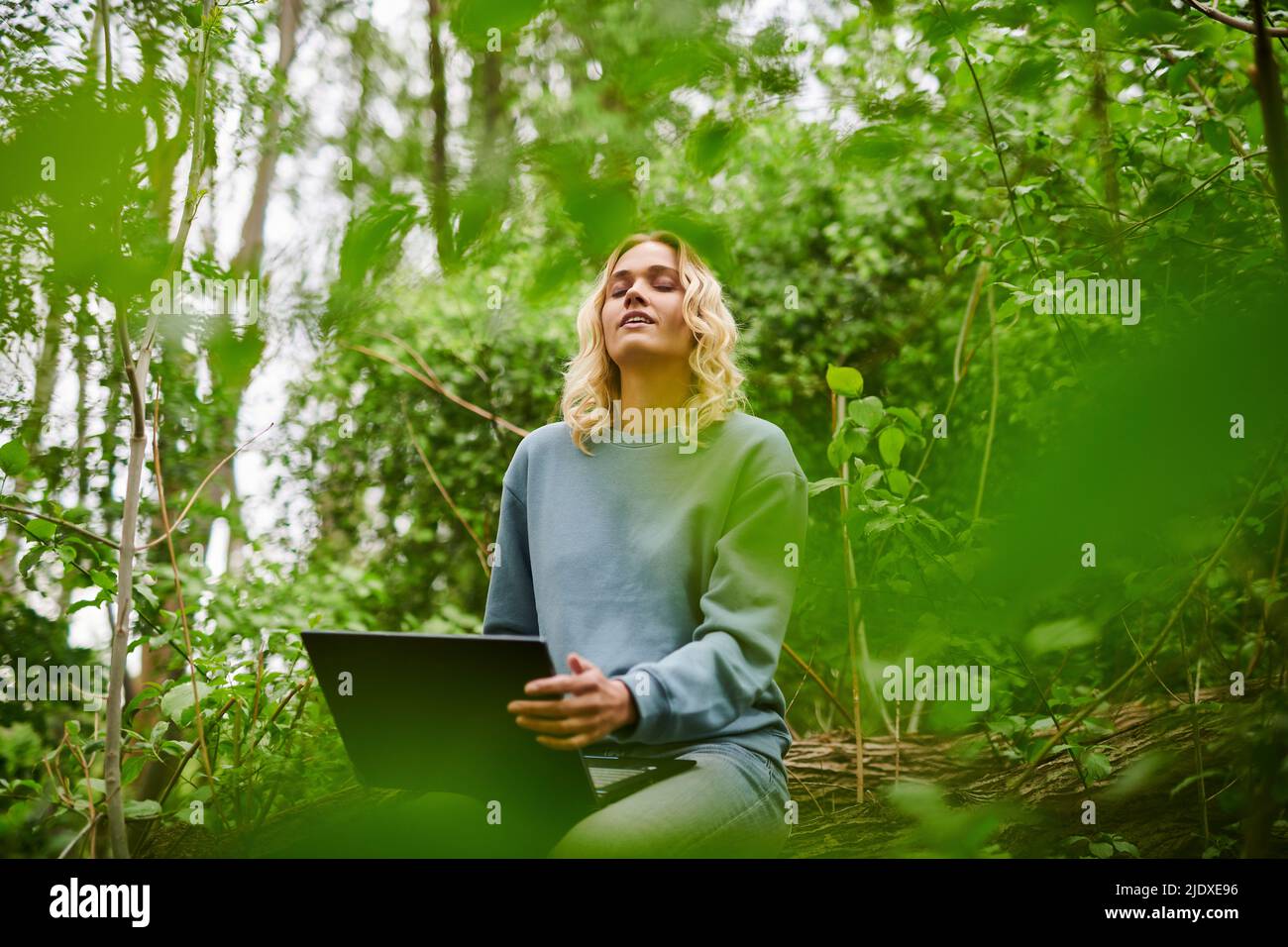 Young freelancer relaxing in nature and using laptop Stock Photo
