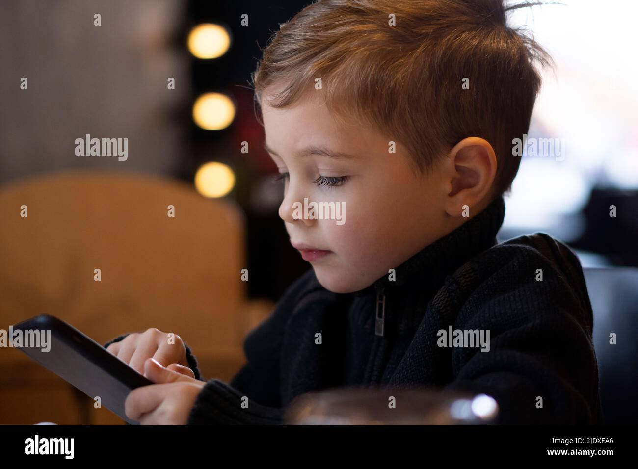 Cute boy using smart phone in winter Stock Photo