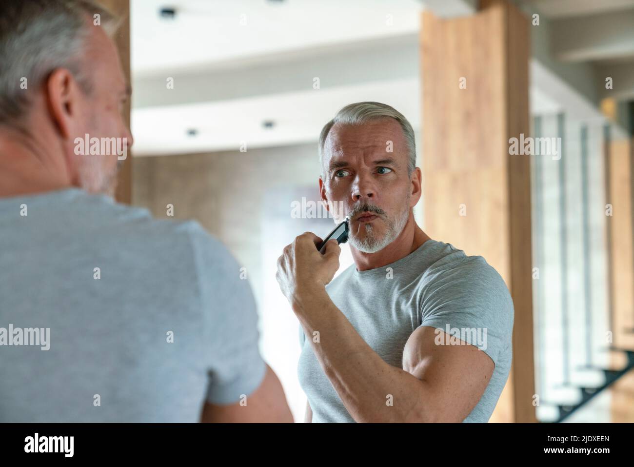 Man shaving with electric razor at home Stock Photo