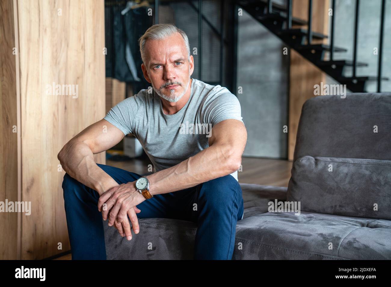 Man sitting on sofa at home Stock Photo