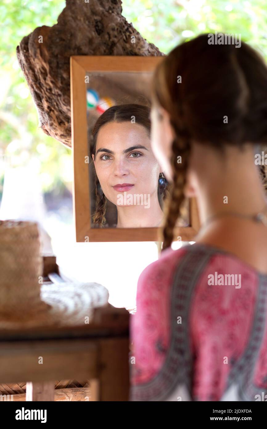 Confident woman looking at herself in mirror Stock Photo