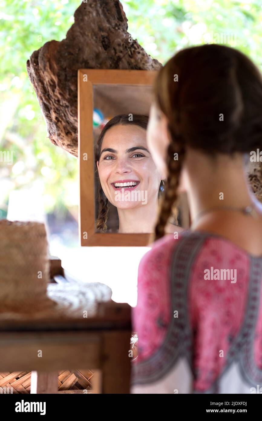 Smiling woman looking in mirror Stock Photo