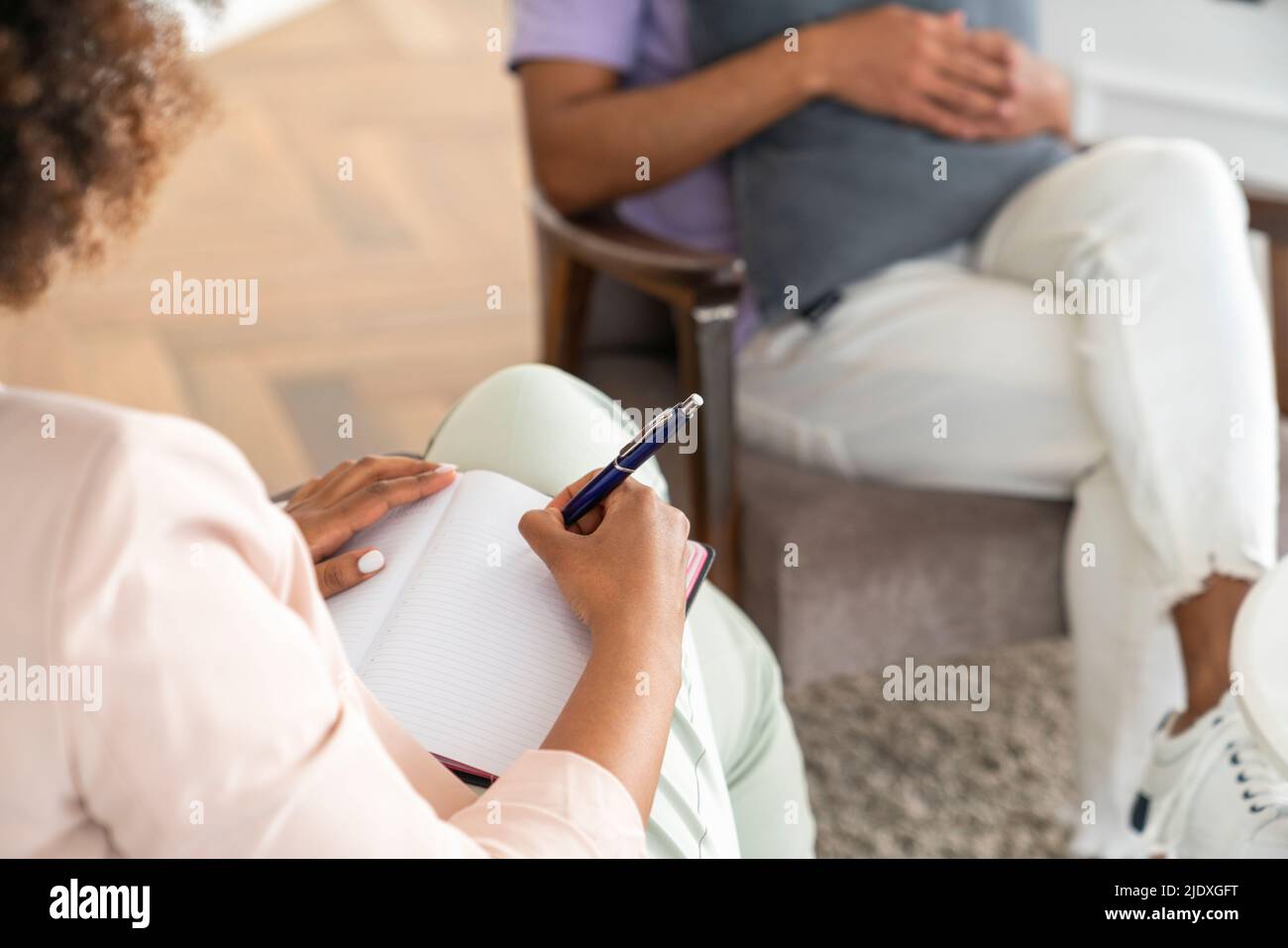Psychologist writing in diary with pen at office Stock Photo