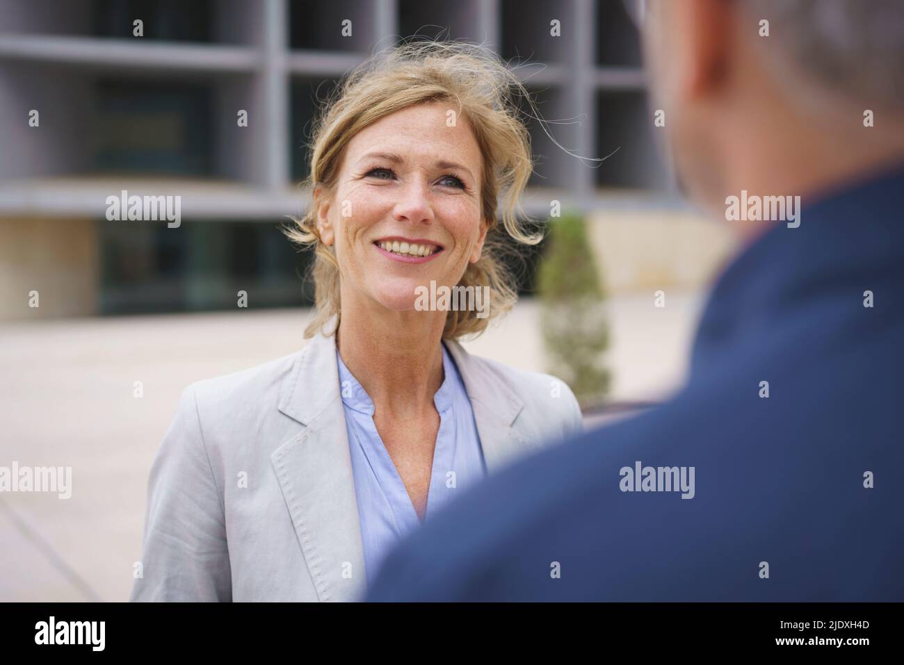 Smiling mature businesswoman discussing with colleague Stock Photo