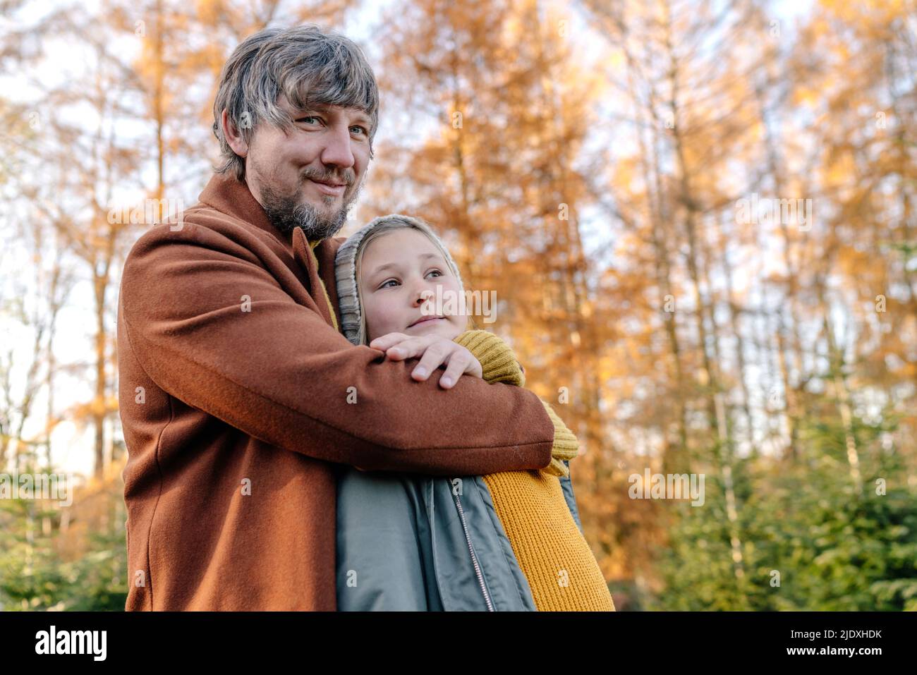 Smiling father with daughter standing in front of trees Stock Photo - Alamy