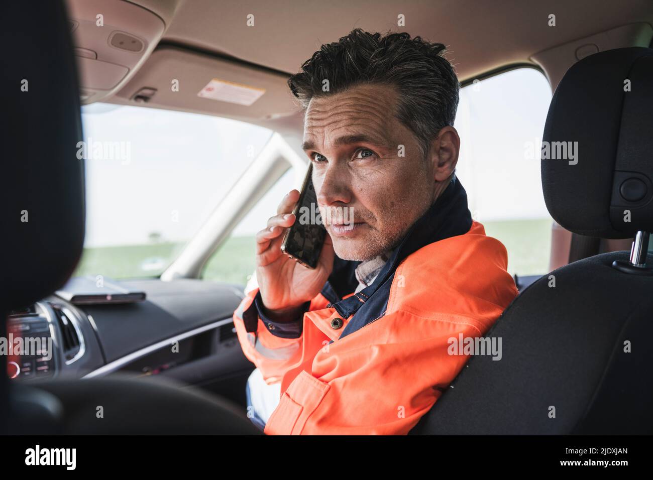 Engineer talking on mobile phone sitting in car Stock Photo