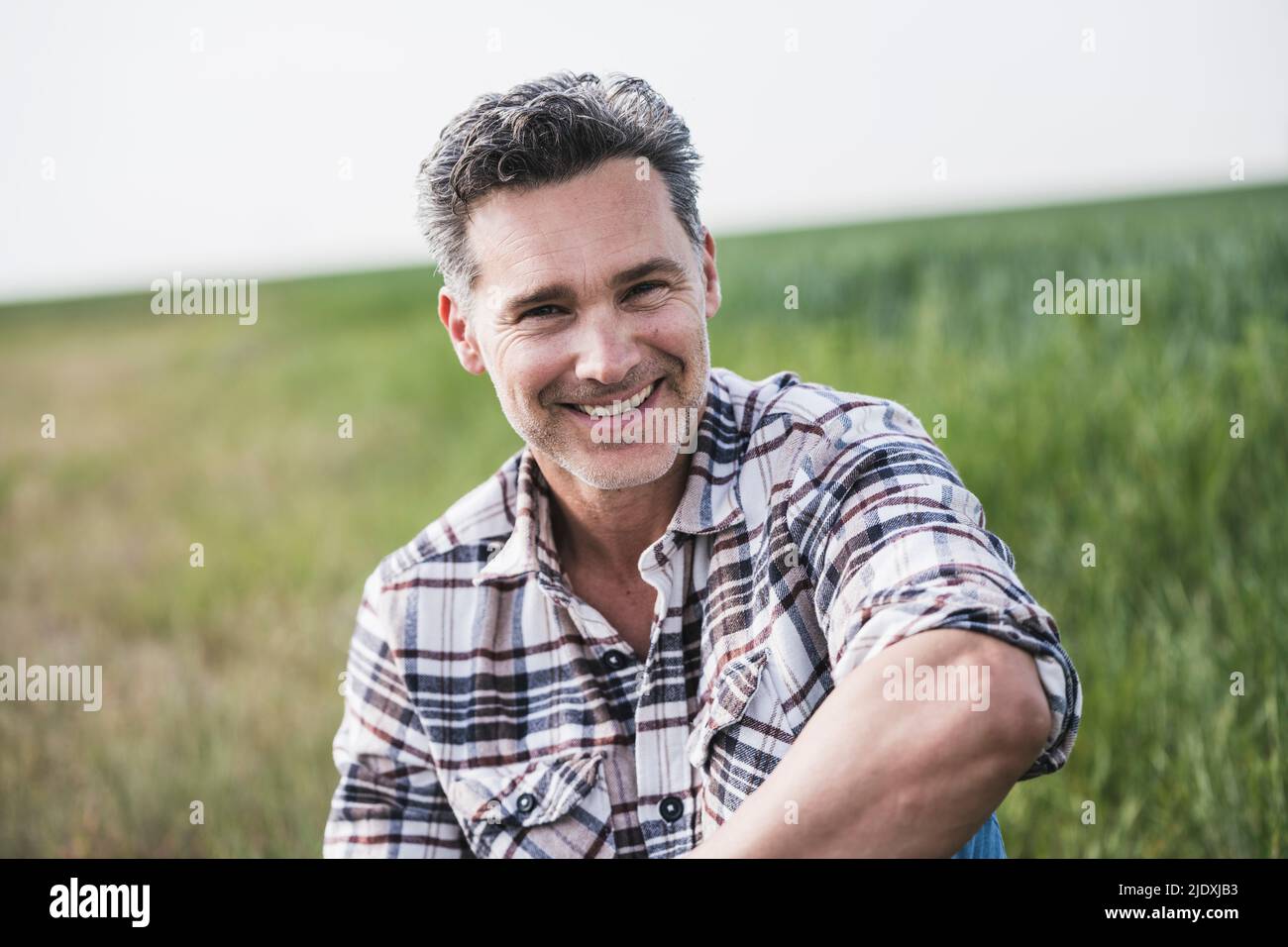 Attractive happy man sitting on hi-res stock photography and images - Alamy