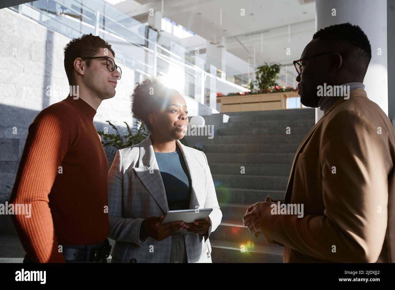 Businessman discussing with colleagues in modern office Stock Photo
